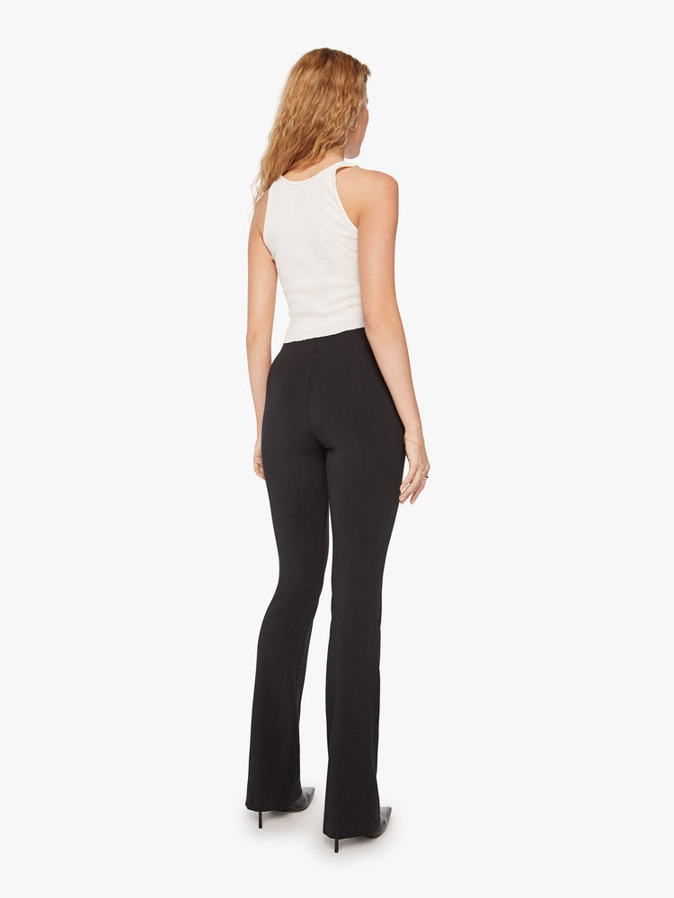Back view of a womens black high rise pant featuring a fitted flare leg.