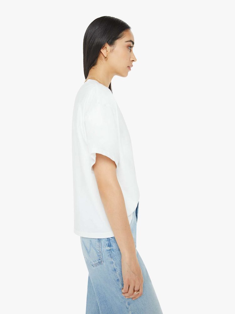 A side view of a woman wearing a white oversized tee