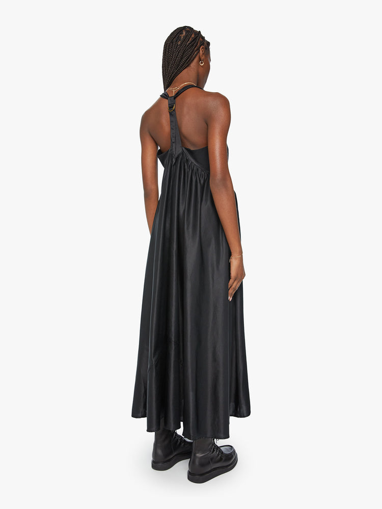 Back view of a woman faded black hue dress and features a square neck with extra long straps, front pockets, a gathered waist and an ankle-length hem.
