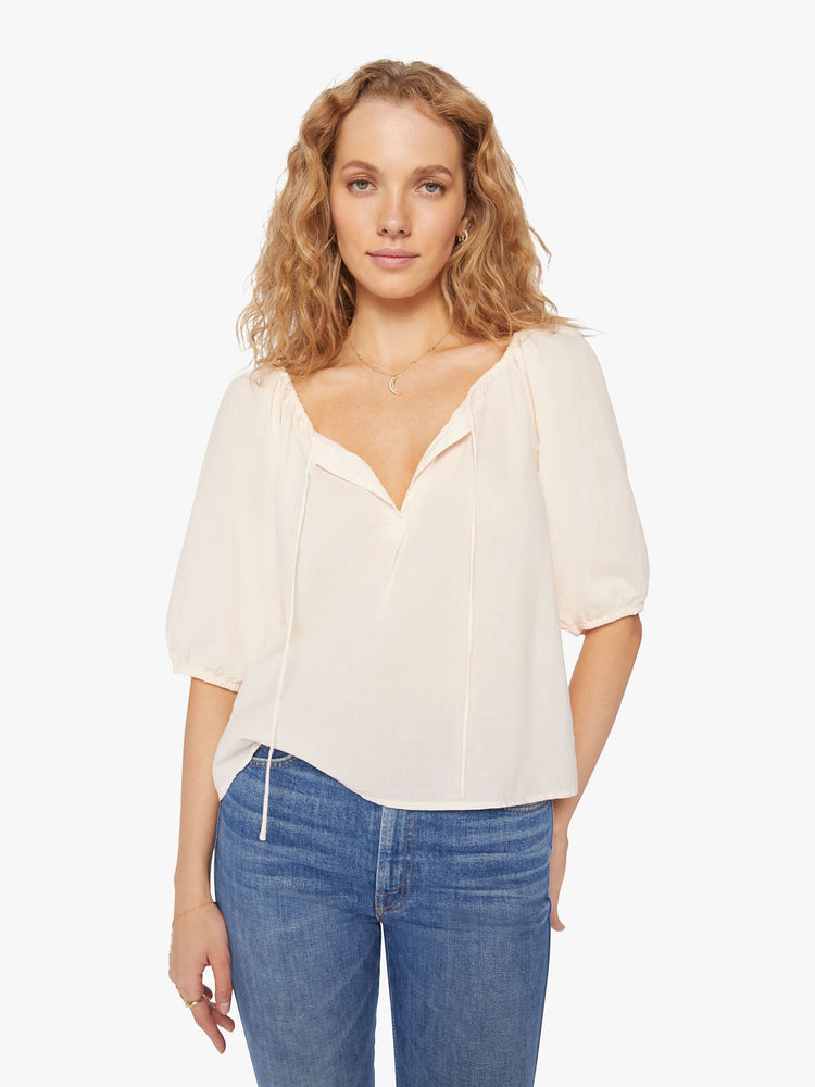 Front view of a woman creamy peach blouse  with a gathered scoop neck that ties, 3/4-length balloon sleeves.