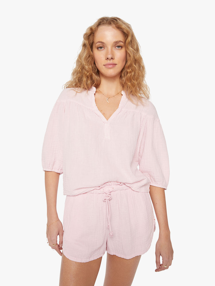 Front view of a woman baby pink top designed with a V-neck, 3/4-length balloon sleeves.