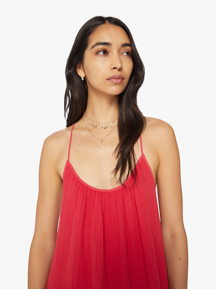 Close up view of a woman red midi dress designed with a gathered scoop neck, spaghetti straps and a racerback.