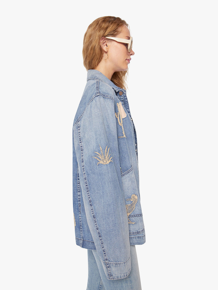WOMEN side view of a jacket in a mid-blue wash with fading and embroidered details inspired by the landscape of Joshua Tree.