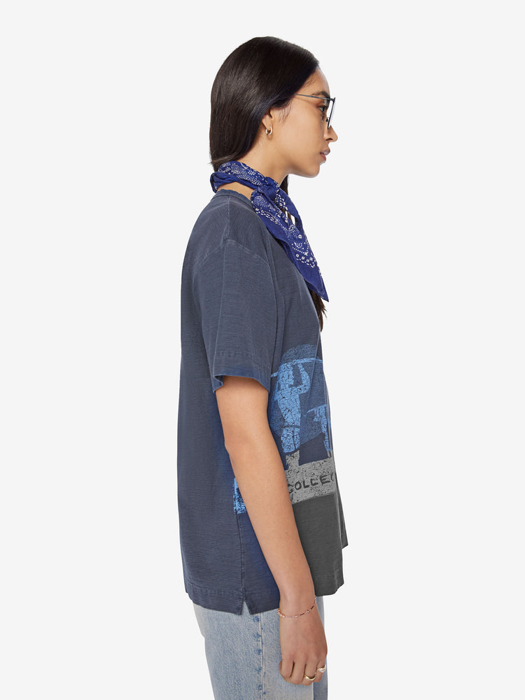 Side view of a woman in black tee with a blue surfer graphic, and features drop shoulders and a boxy fit.