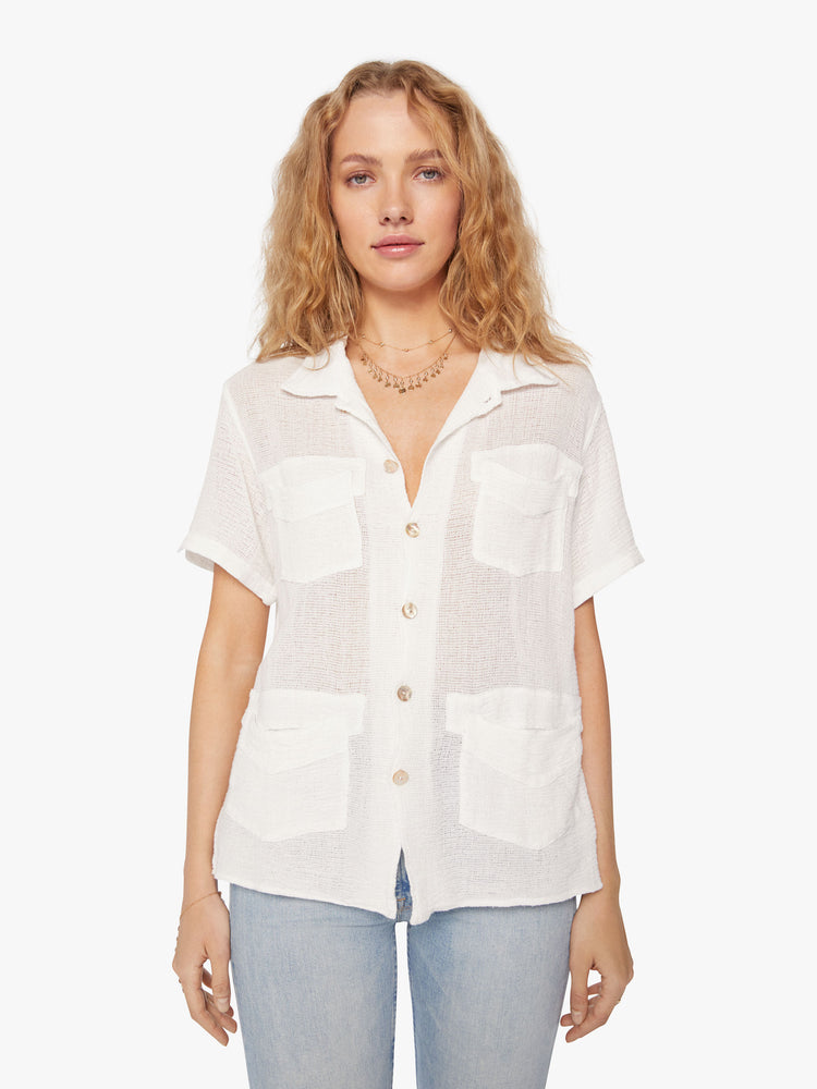 Front view of a woman semi sheer white short-sleeve collared shirt with front patch pockets and boxy fit.