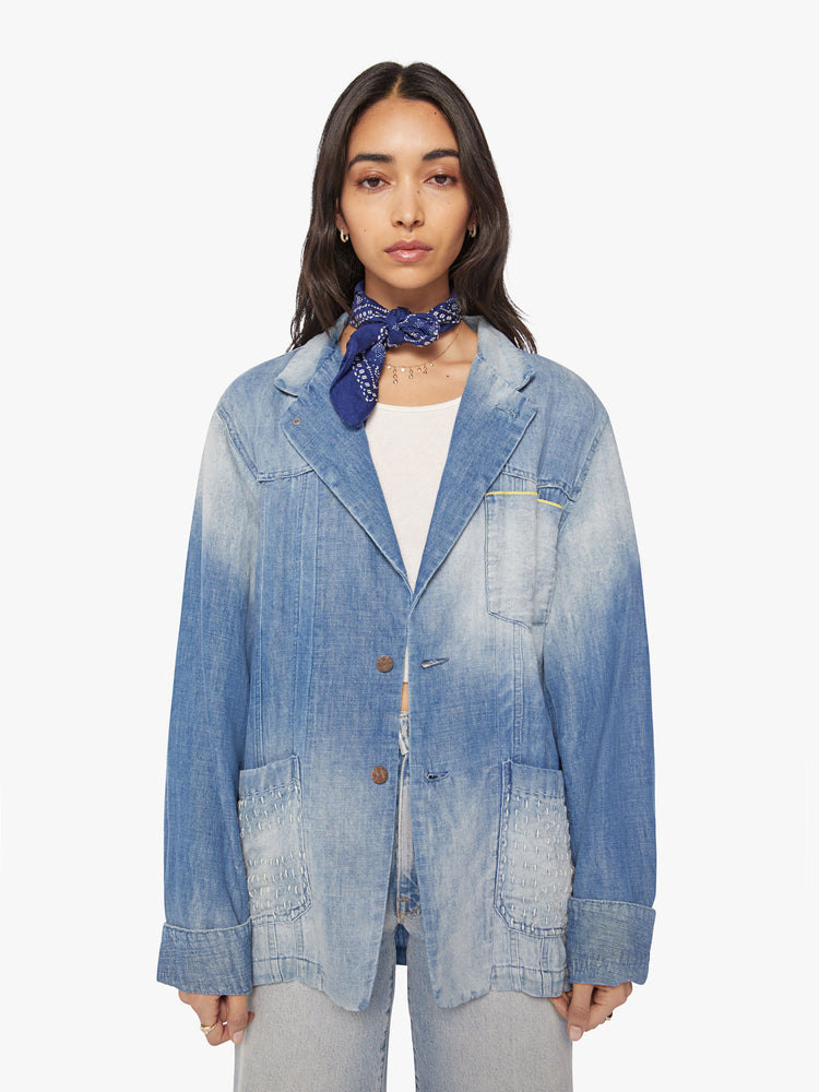 Front view of a woman denim blazer with a notched collar, front patch pockets, buttons down the front in a vintage blue wash.