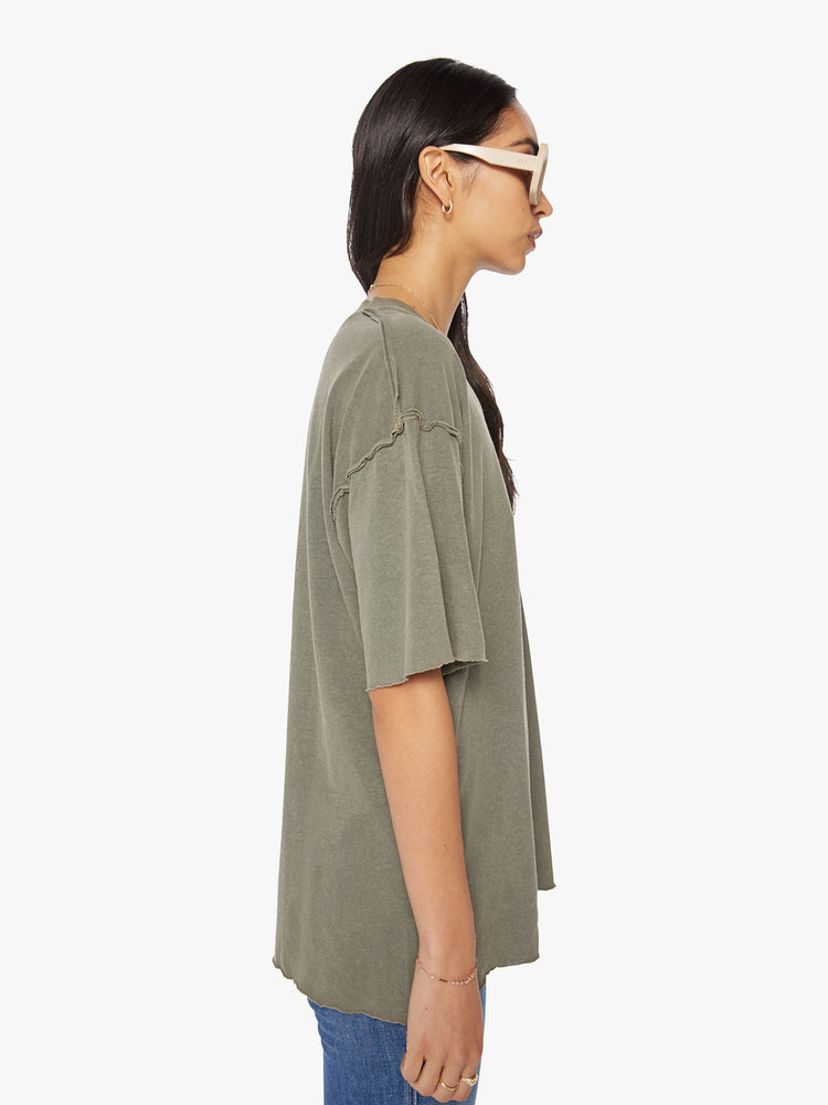 Side view of a woman in a cropped crewneck tee with drop shoulders, a boxy fit in a sage green hue.