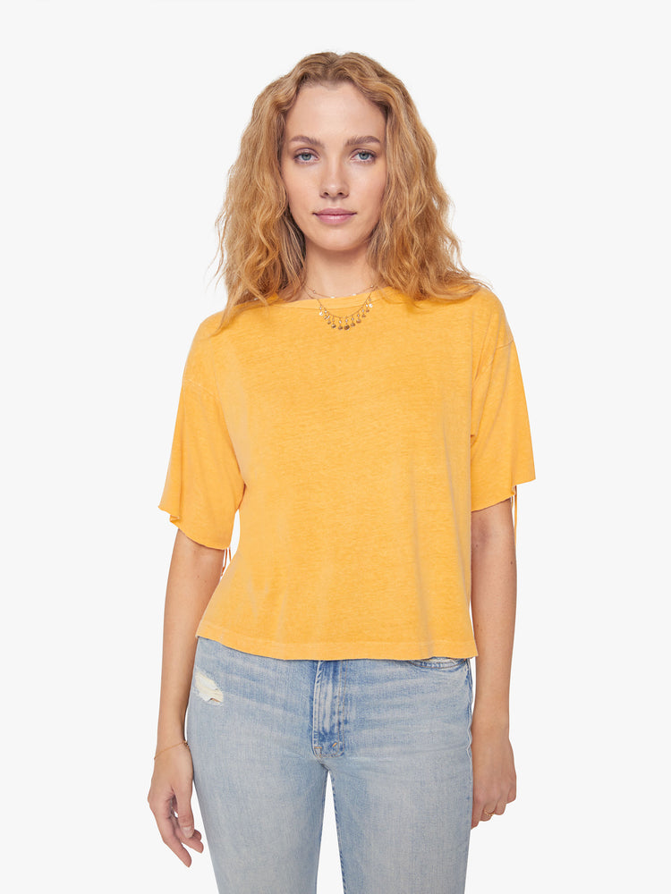 Front view of a woman crop tee with drop shoulders, a boxy fit in a bright yellow hue with fringe across the back.