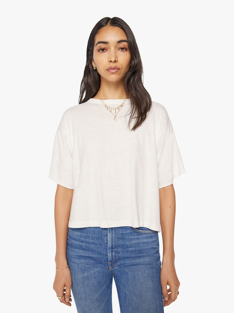Front view of a woman crop tee with drop shoulders, a boxy fit in an off-white hue with fringe across the back.