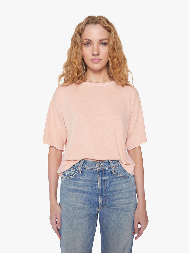 Front view of a woman crop tee with drop shoulders, a boxy fit in a soft pink hue with fringe across the back.