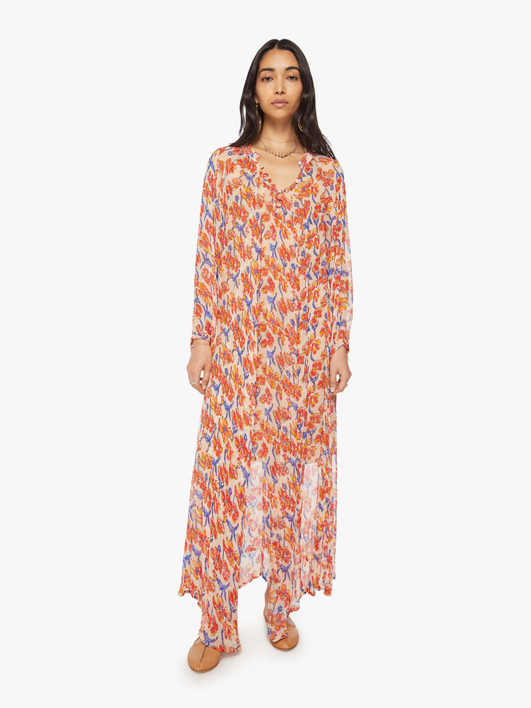 Front full body view of a woman's maxi dress in off-white chiffon with a watercolor floral print in orange and navy with voluminous sleeves and has an A-line cut.