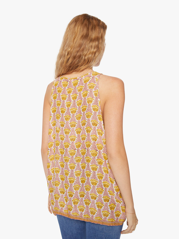 Back view of a woman crewneck tank designed in a pink and yellow tulip print and a hip-grazing hem.