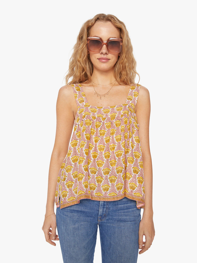 Front view of a woman's top in a  pink and yellow tulip print, and detailed straps and buttons in the back.