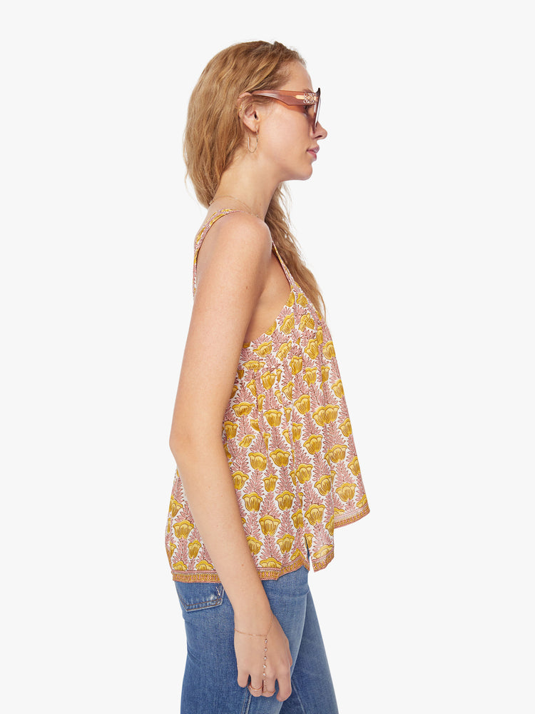 Side view of a woman's top in a pink and yellow tulip print, and detailed straps and buttons in the back.