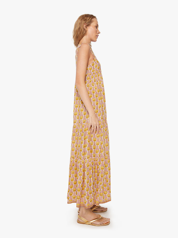 Side view of woman's dress in a pink and yellow tulip print and slim adjustable ties at the shoulders.
