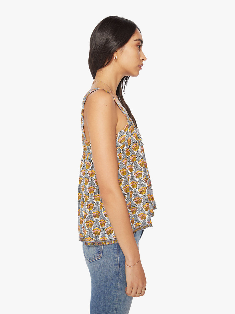 Side view of woman's top in a blue and yellow tulip print, and detailed straps and buttons in the back.