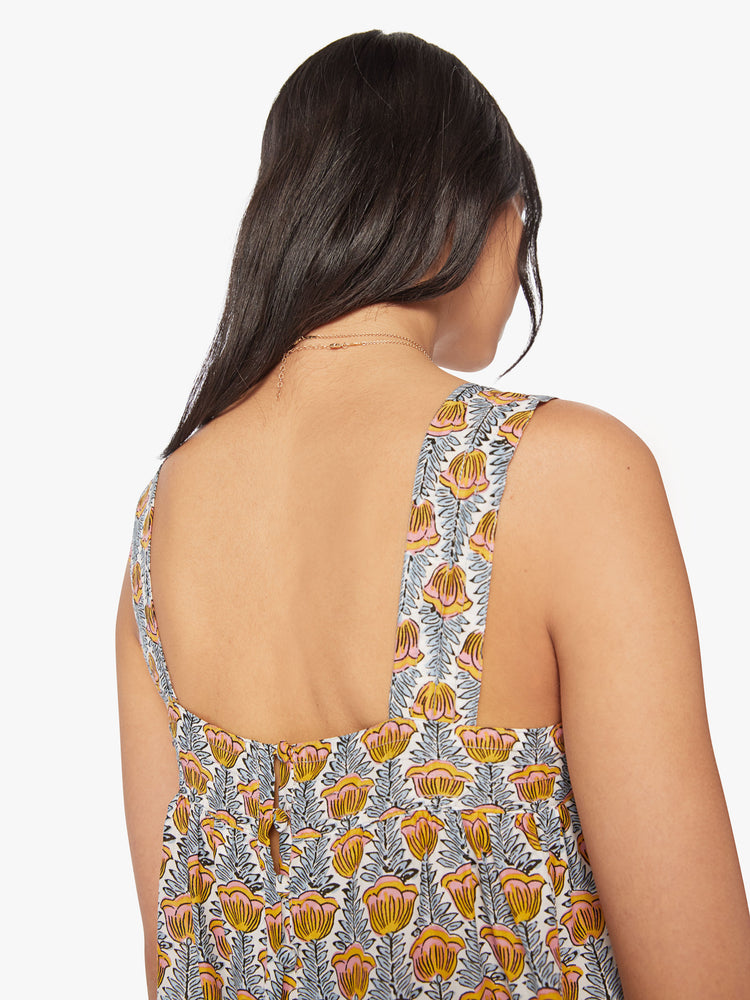 Close up view of woman's top in a blue and yellow tulip print, and detailed straps and buttons in the back.