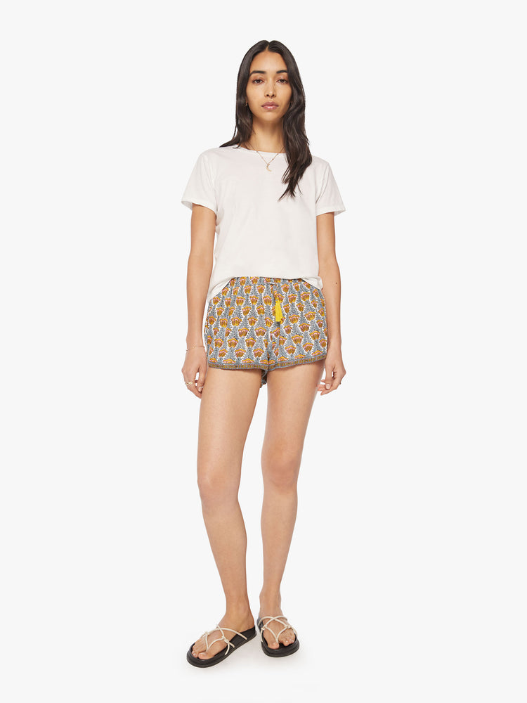 Front view of a woman blue and yellow tulip print lightweight shorts with an elastic waist with drawstring, side pockets and scalloped hemline.