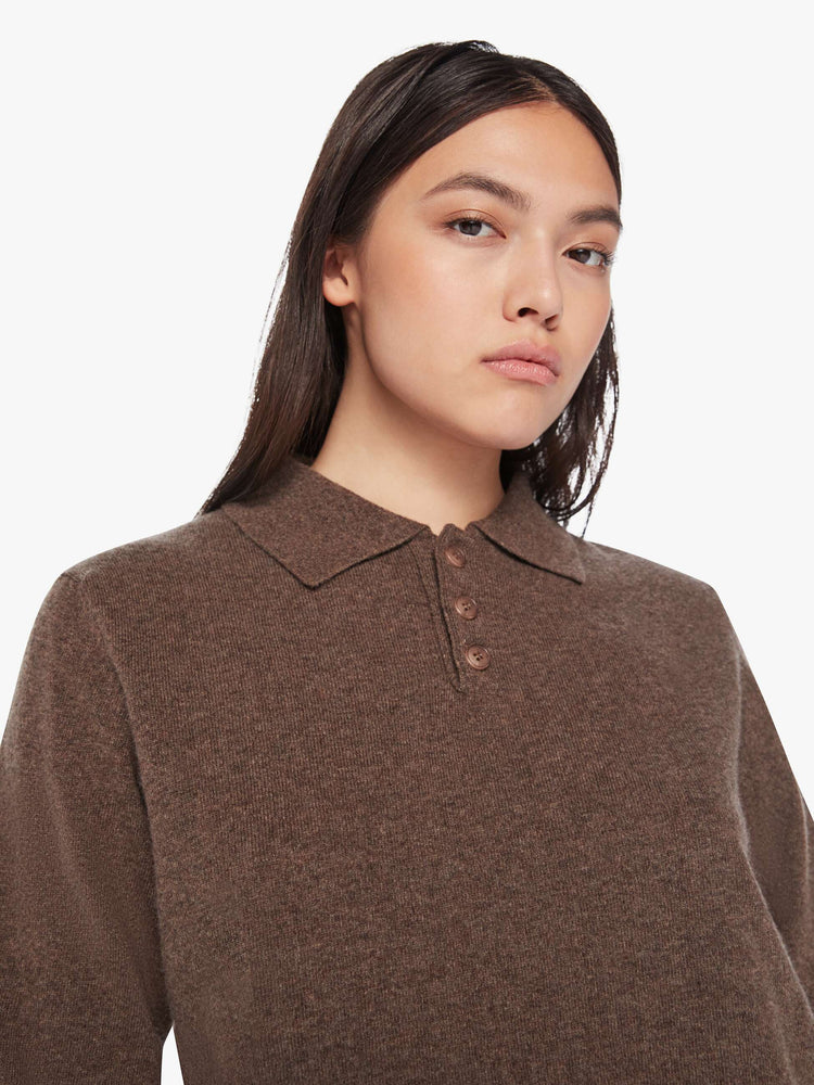 Close up view of a woman polo in a brown hue with a collar, buttoned V-neck, long sleeves and a loose fit.