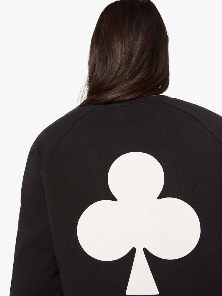 Back view of a woman crewneck sweatshirt with a relaxed shape with raglan sleeves and is decorated with a white club graphic on the back and a logo on the front.
