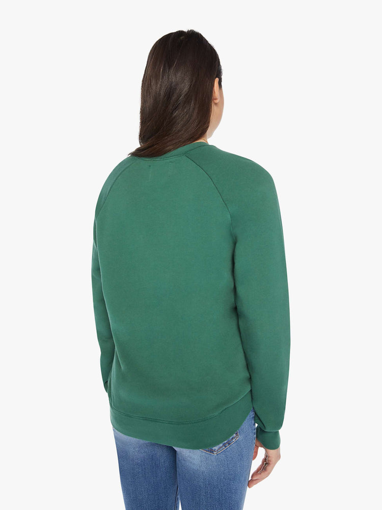 Back view of a woman crewneck sweatshirt in a hunter green hue with a white anchor and has a relaxed shape with raglan sleeves.