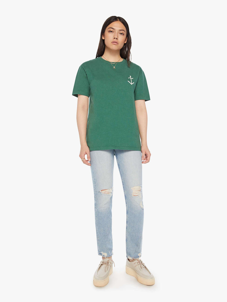 Full body view of a woman green tee with a white anchor on the chest, has a ribbed crewneck and a straight fit.