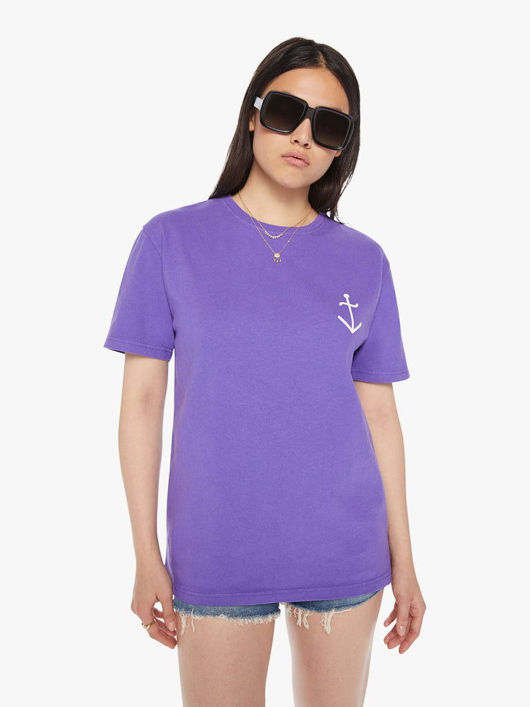 Front view of a woman purple tee with a white anchor on the chest, has a ribbed crewneck and a straight fit.
