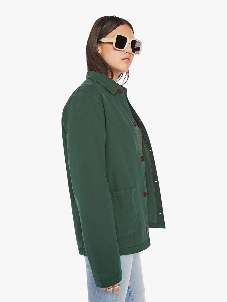 WOMEN side view of a jacket in hunter green hue with front patch pockets, long sleeves, buttons down the front and a boxy fit.