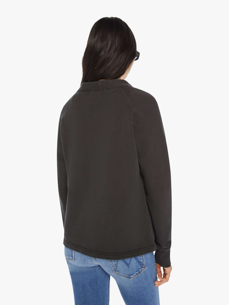 Back view of a woman black button-up cardigan with a V-neck, front patch pockets and a slightly boxy fit.