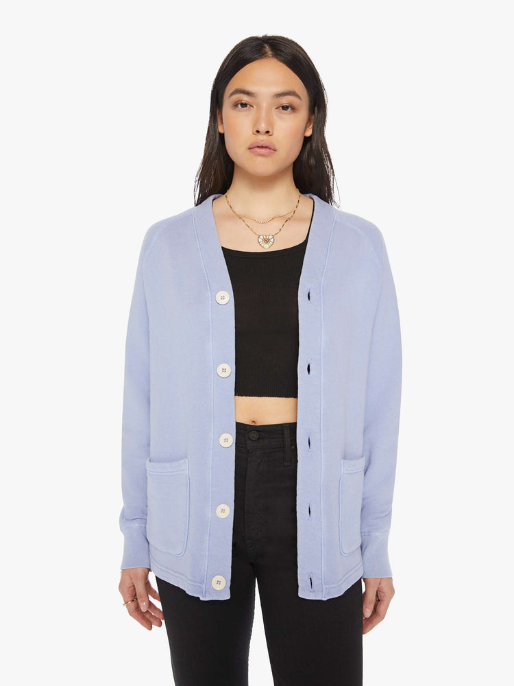 Front view of a woman light blue button-up cardigan with a V-neck, front patch pockets and a slightly boxy fit. 