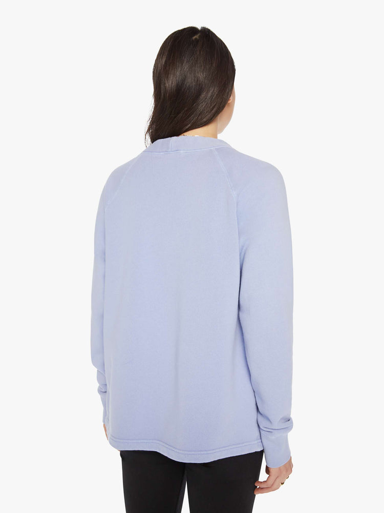 Back view of a woman light blue button-up cardigan with a V-neck, front patch pockets and a slightly boxy fit.