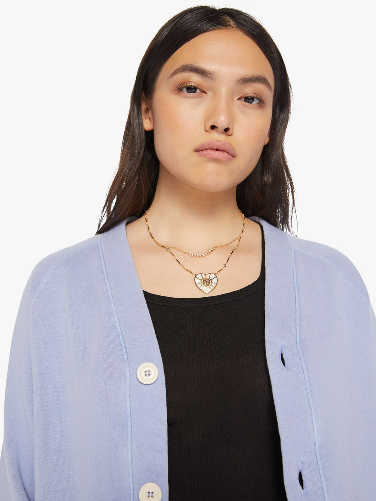 Close up view of a woman light blue button-up cardigan with a V-neck, front patch pockets and a slightly boxy fit.