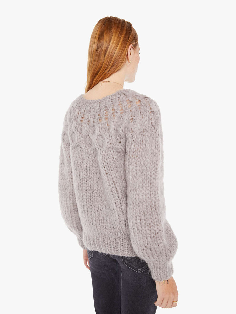 Back view of a womens chunky knit sweater in a grey hue featuring balloon sleeves and ribbed hems.