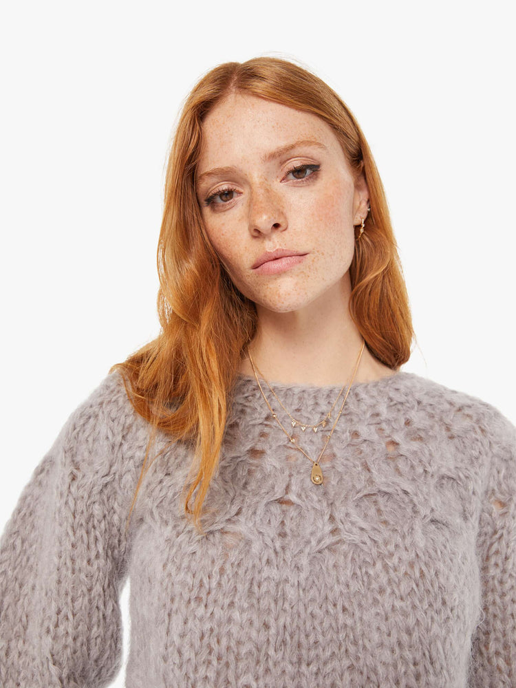 Front close up view of a womens chunky knit sweater in a grey hue featuring balloon sleeves and ribbed hems.
