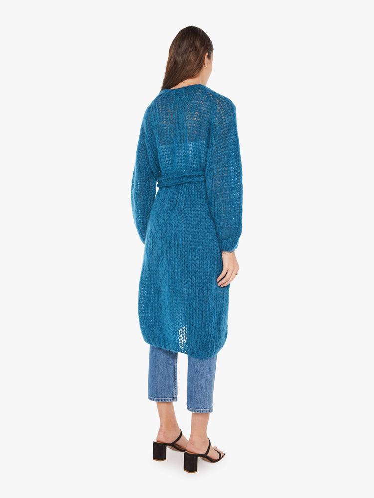 Back view of a womens loose knit blue cardigan coat featuring billow sleeves and a knit belt tie.