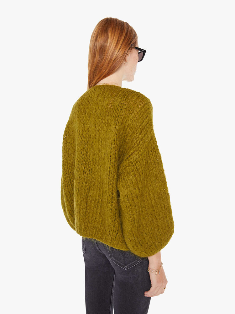Back view of a womens chunky knit cardigan in a khaki hue featuring billow sleeves.