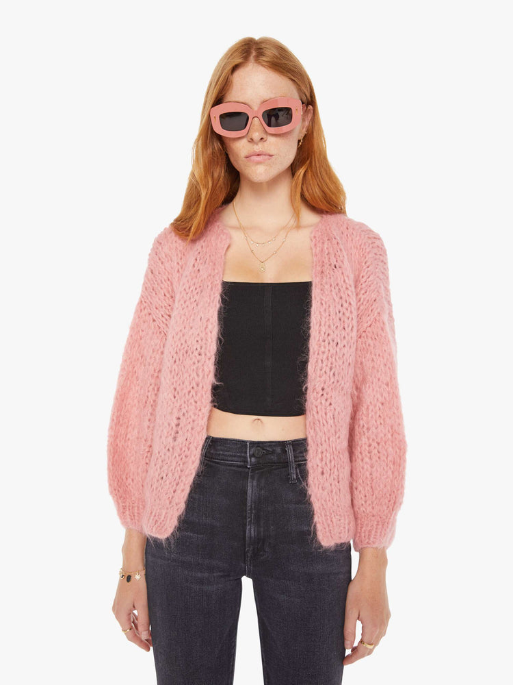 Front view of a womens chunky knit cardigan in a soft pink hue featuring cropped billow sleeves.