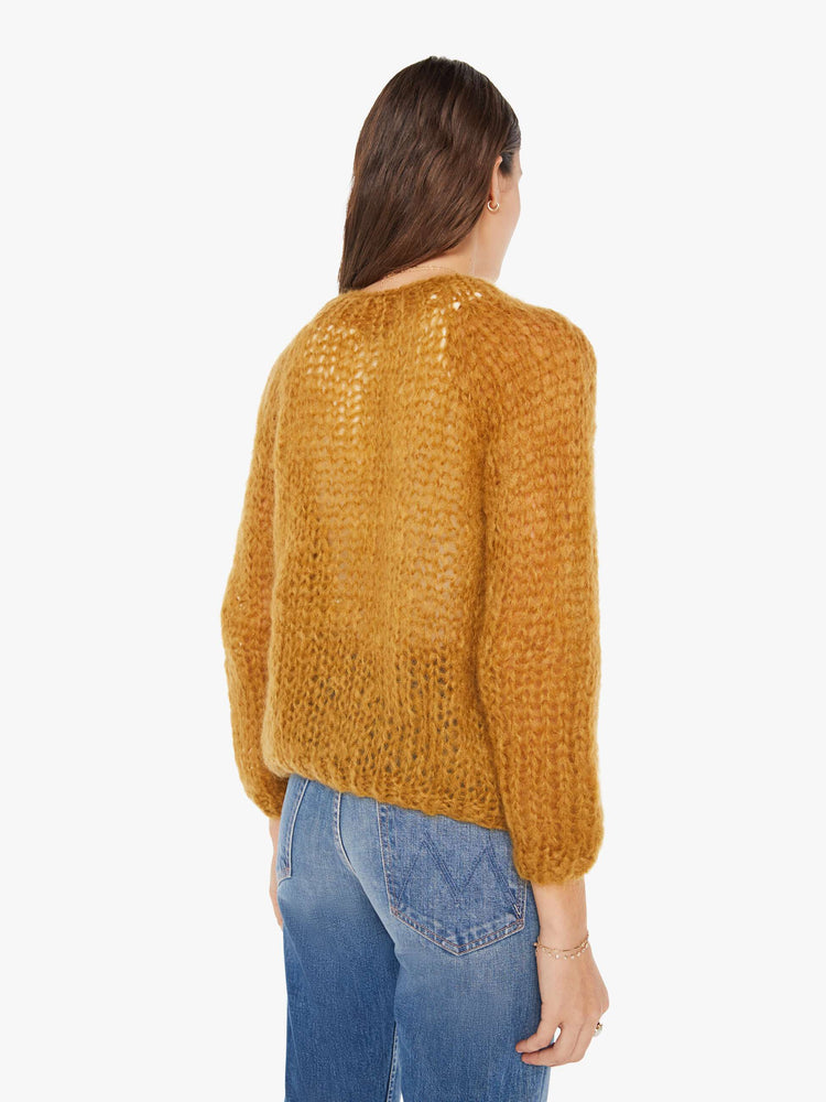 Back view of a womens chunky knit cardigan in a warm brown hue featuring cropped billow sleeves.