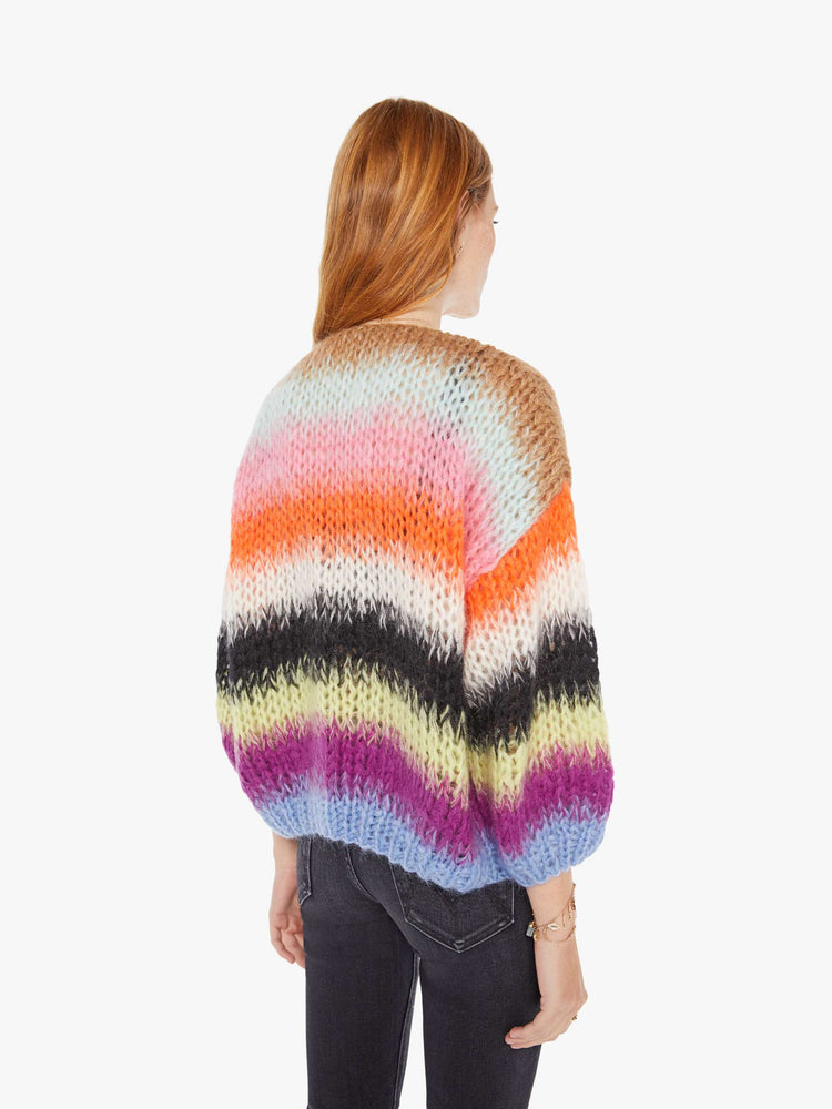 Back view of a womens chunky knit cardigan in multi color stripes, featuring a cropped body with balloon sleeves.