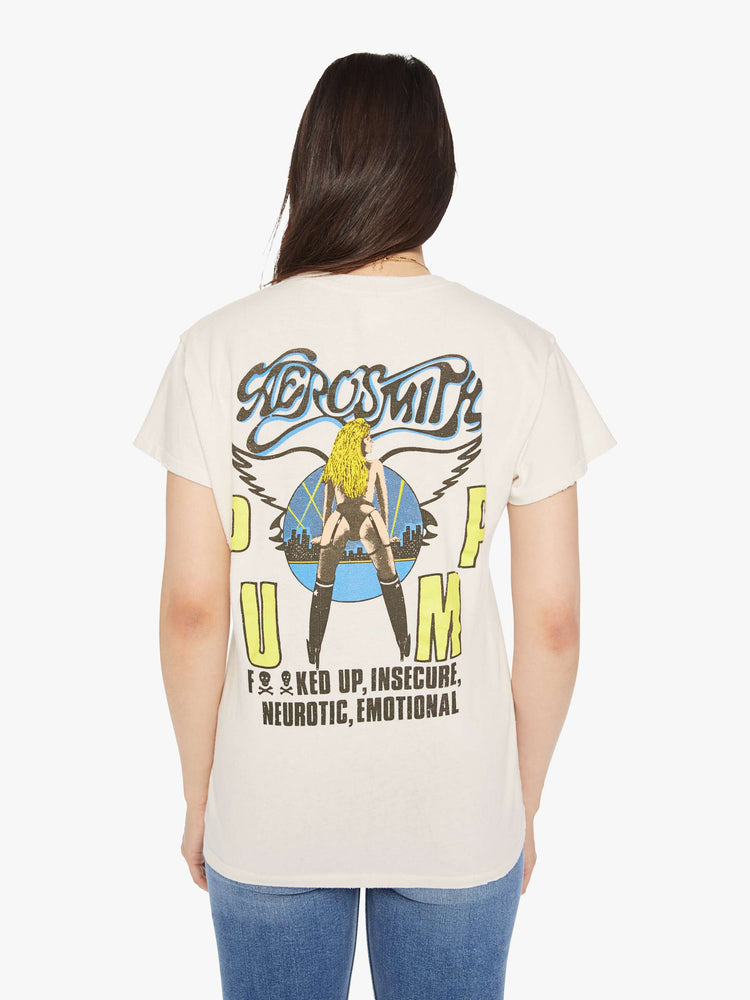 Back view of a woman distressed crewneck tee in white, the tee riffs on Aerosmith merch from 1990 with neon graphics and bold text on the front and back.