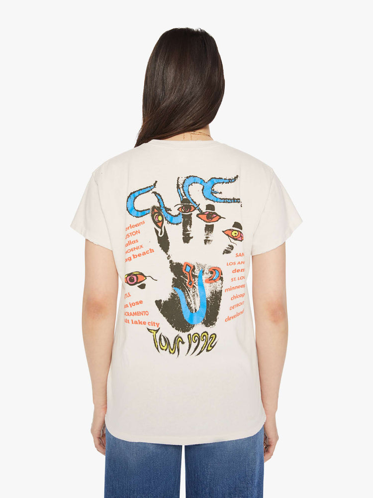 Back view of a woman distressed crewneck tee in white, the tee riffs The Cure's tour merch from 1992 with trippy graphics and bold text on the front and back.
