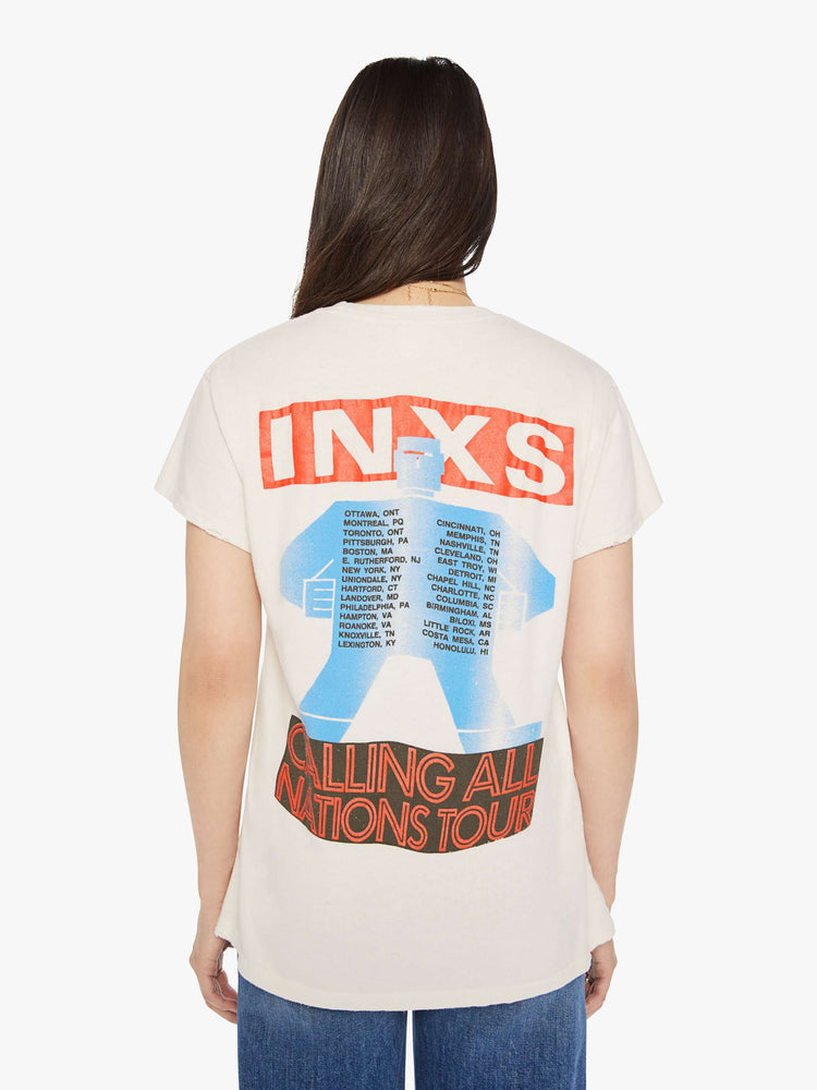 Back view of a woman distressed crewneck tee in white, the tee pays homage to INXS' Calling All Nations tour with bold graphics on the front and back.