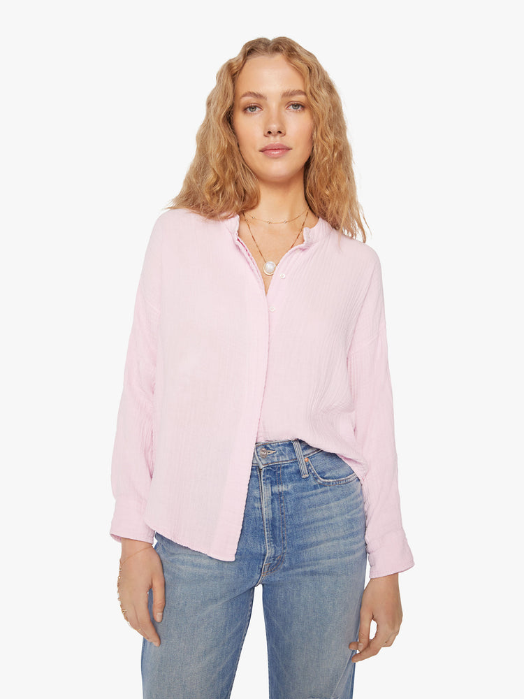 Front view of a woman baby pink blouse with a V-neck with buttons down the front, a curved hem and an airy fit.