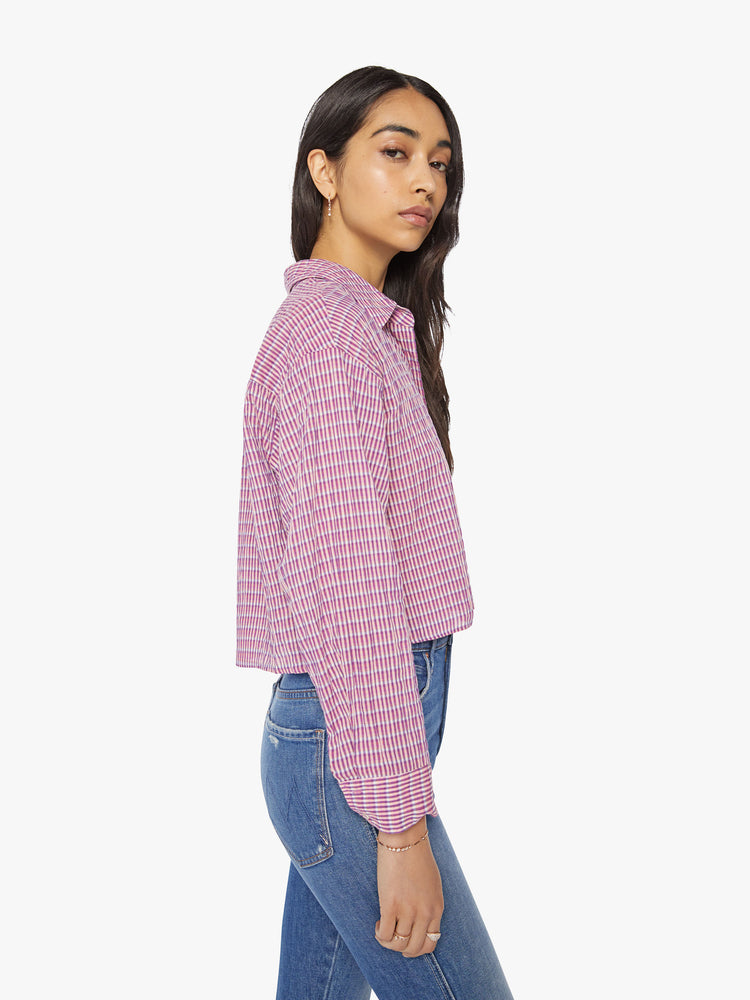 Side view of a woman coral-pink shirt with cropped hem, vneck with buttons down the front.