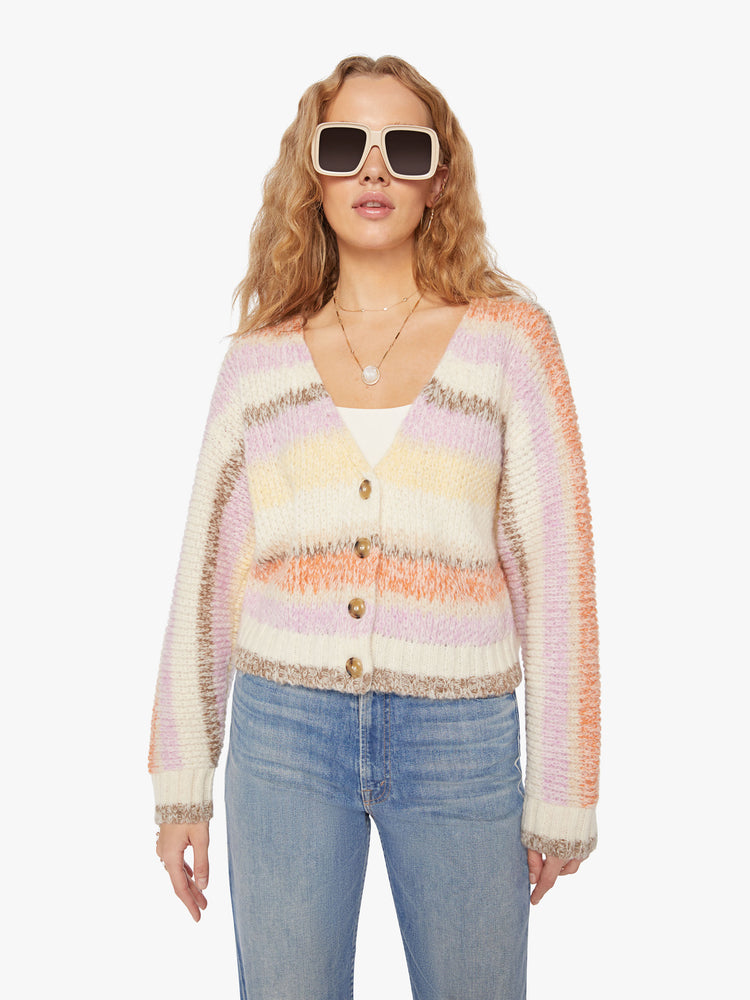 Front view of a woman vneck, long sleeve, cropped hem, buttons down the front cardigan in a pastel horizontal stripe pattern.