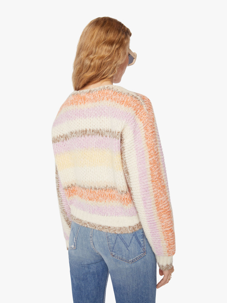 Back view of a woman vneck, long sleeve, cropped hem, buttons down the front cardigan in a pastel horizontal stripe pattern.
