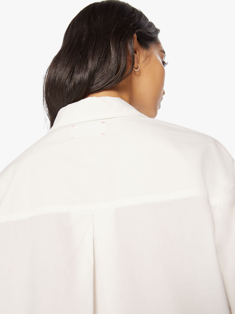 Back swatch view of a woman white cropped button-up designed with drop shoulders, a cropped hem and boxy fit.