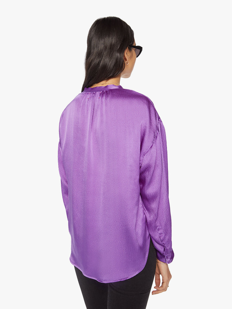 Back view of a woman longsleeve blouse in a silk purple topaz hue designed with a V-neck, drop shoulders and a flowy fit.