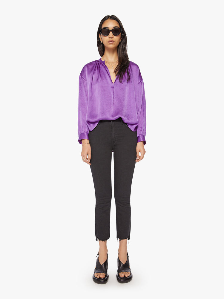 Full body view of a woman longsleeve blouse in a silk purple topaz hue designed with a V-neck, drop shoulders and a flowy fit.
