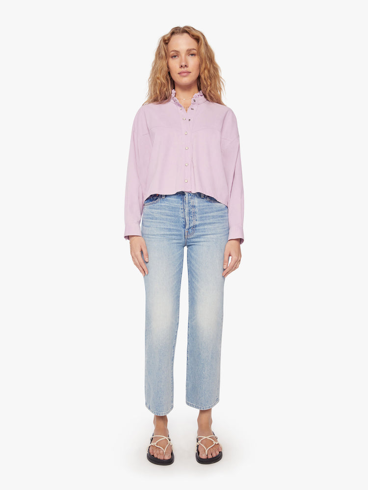 Full body view of a woman soft lilac shirt with a ruffled V-neck that buttons, drop shoulders, long sleeves, a cropped hem and a boxy fit.